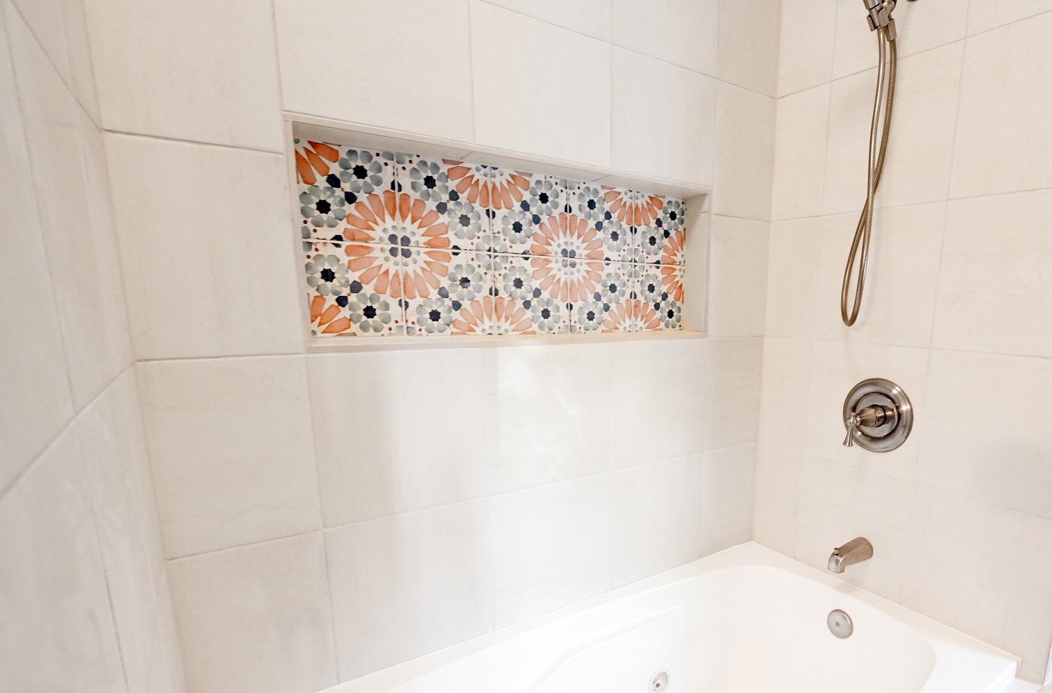 Bathroom remodel with large white square bath tile with accent soap nook